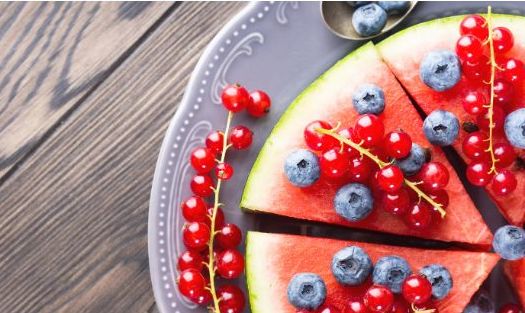 Watermelon topped with redcurrants and blueberries